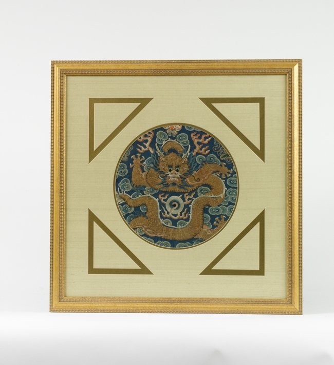 A EMBROIDERED DRAGON ROUNDEL,QING DYNASTY : Worked in gold and silver-wrapped and multicolored threads with eight dragon roundels, the dragons couched in very pale gold and silver thread shown leaping amidst clouds above roiling, froth-capped w
