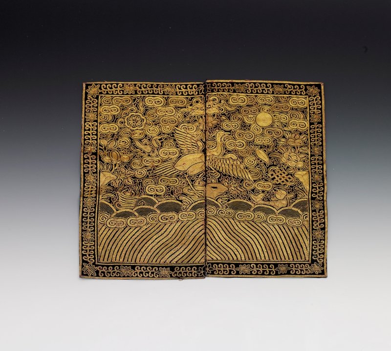 A silk military badge of rank,buzi, 19th Century: 19th Century Embroidered with a phoenix in satin stitch and couched gold threads amidst auspicious objects and clouds. Standing atop rockwork and crashing waves above the lishui stripe. 12 x 11 in