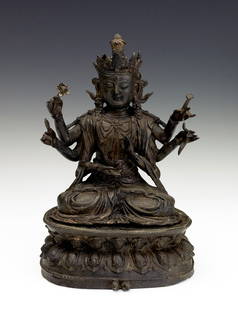 A bronze figure of Shadakshari, Ming Dynasty: Ming Dynasty Seated in dhyanasana on a double-lotus base with beaded rim holding a lotus blossom and a mala in his upper set of hands, clad in a sheer dhoti with the folds elegantly pooling below the