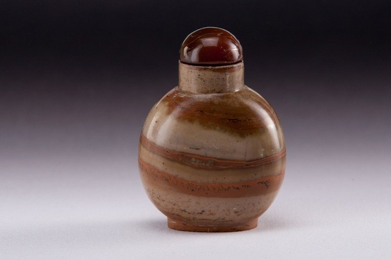 A soapstone snuff bottle, 19TH CENTURY: 19TH CENTURY Ovaly shaped decorated with a layers of caramel color. 2 3/4 in. tall.