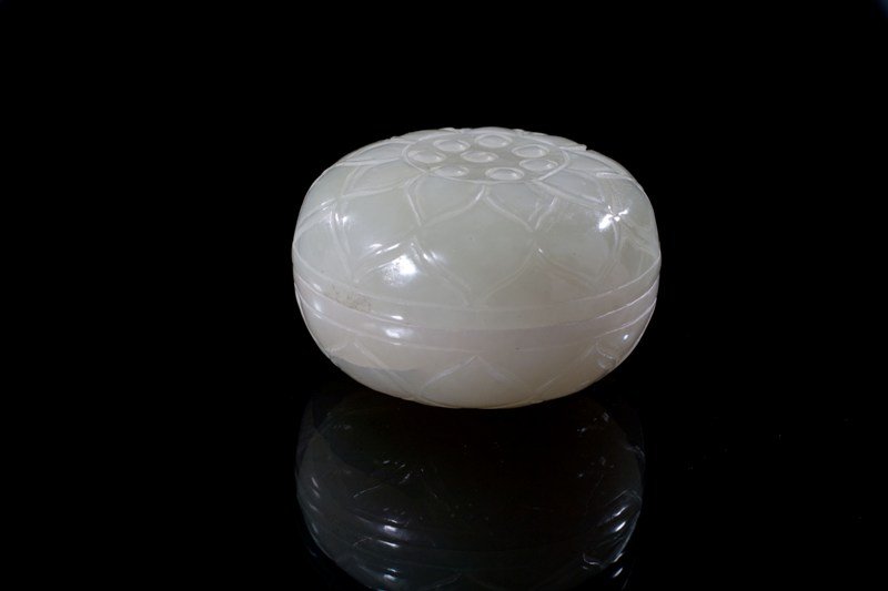 A white jade lotus-form box and cover, 18-19TH CEN: 18-19TH CENTURY White jade even tone overall, carving of a lotus- leaf box and cover. Item is symmetric and spheral. 2 1/8'' diam