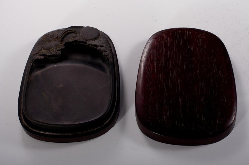 A duan inkstone and box, 19TH CENTURY: 19TH CENTURY Solid dark- brown tone overall, decorated with a sun surrounded by clouds. 7 1/8'' x 5''