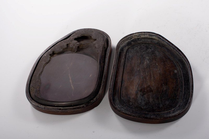 A duan inkstone and box, 19TH CENTURY: 19TH CENTURY Solid dark- brown tone overall, decorated with a flaming dragonsurrounded by clouds and the sun. 7"X 5 1/8"