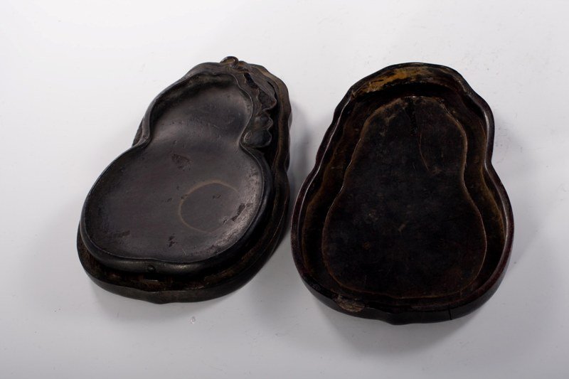 A duan inkstone and box, 18TH CENTURY: 18TH CENTURY Solid dark- brown tone overall, decorated waves and clouds. 8" x 5 1/4"