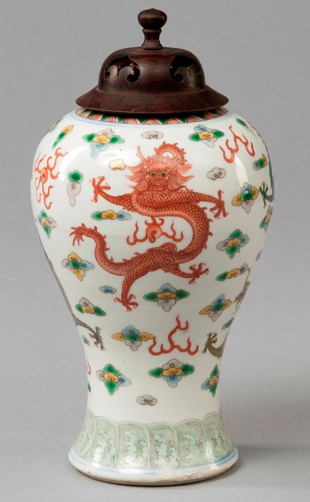 A WUCAI DRAGON VASE AND COVER: 19TH CENTURY Wide- cylinder shaped body decorated with a green dragon, yellow dragon and red- orange dragon. All surrounded by flaming pearls and clouds in forms of flowers. Cover is dark brown colour