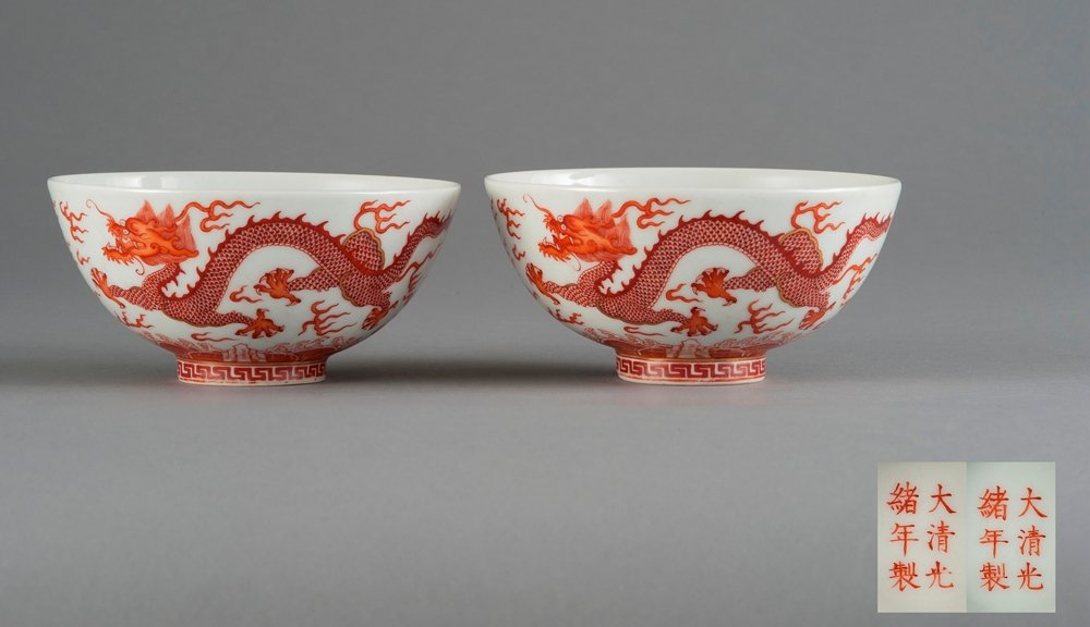 A PAIR OF COPPER- RED GLAZED DRAGON BOWLS: MARK AND PERIOD OF GUANGXU The pair of dragon bowls is overall a marble white tone. The exterior is decorated with two orange claw dragons chasing flaming pearls and surrounded by mists. The interior 