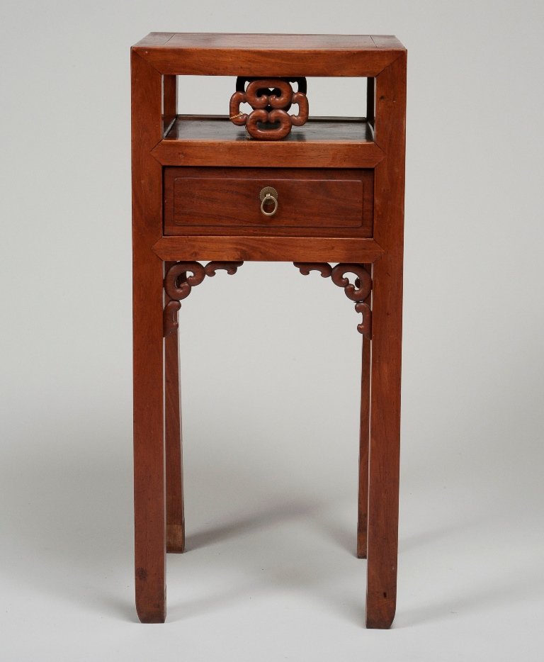 A CHINESE HUANGHUALI CORNER LEG STAND: 19TH CENTURY The leg stand is of dark brown colour tone, the leg stand has an overall square shape. The leg stand has four long legs. The leg stand also has a square- shaped draw on the middle of the 
