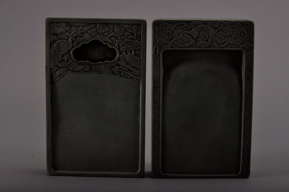 A PAIR OF CHINESE INKSTONES: 松花硯兩方 The pair of ink stones is both dark granite black colour tone overall. The upper portion of one ink stone is decorate with a large bird surrounded by trees. Th