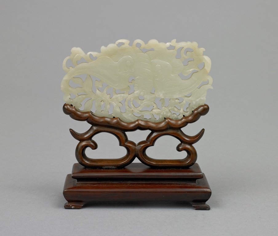 A WHITE JADE CARVING OF BAT PLAQUE: 清 19世紀 白玉雕螭紋擺件 19TH CENTURY The openwork plaque is of white jade color tone overall with natural inclusions. The carving is of a b