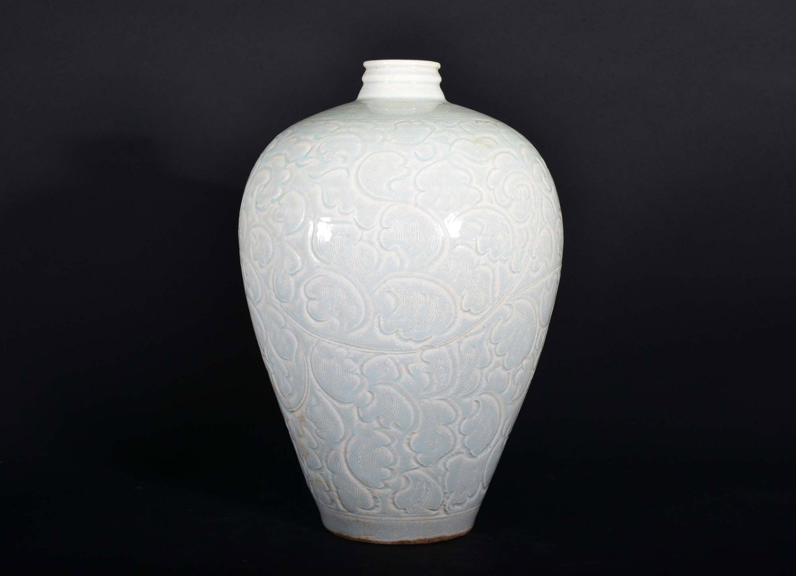 A QINGBAI MEIPING.SONG PERIOD: The meiping with high-shouldered, tapering body is carved with a broad band of scrolling tendrils between double borders. It is covered inside and out with a glaze of pale aquamarine tone .