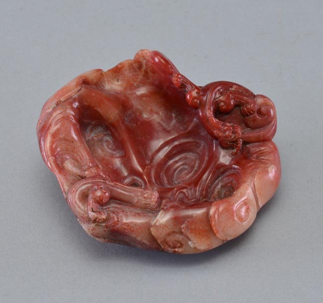 A RED SOAPSTONE CARVING OF DRAGON BRUSHWASHER: 3 15/16 in. (10 cm) diameter.