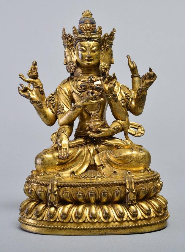 A GILT-BRONZE FIGURE OF USHNISHAVIJAVA: MING DYNASTY The eight-armed three-headed deity seated on a double-lotus base with her arms radiating, holding a bow and arrow and a double-vajra and bowl in her principal hands, the heads slightly ti