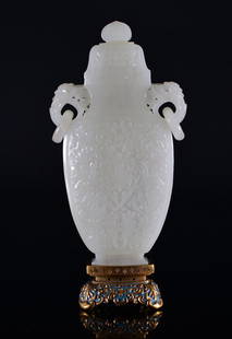 A WHITE JADE CARVING OF VASE AND COVER: the jade vase is of white jade colour tone. The body of the vase is decorate with numerous flower blossoms surrounded with ruyi clouds. The handles of the vase is decorate with a bird's head holding