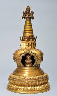 A GILT-BRONZE STUPA: Ming Dynasty the buddhist shrine stands erected, with a double lotus base, the center of the shrine is decorated with a seated buddha. Bordering the seated buddha is colorful rich jewels. On the