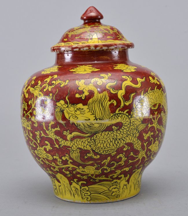A YELLOW-AND RED 'DRAGON ' JAR AND COVER: Mark And Period Of Jiajing The jar is of wide globular-shaped and the exterior is decorated with twin yellow dragons chasing flaming pearls surrounded by ruyi clouds and crashing waves. The base of th