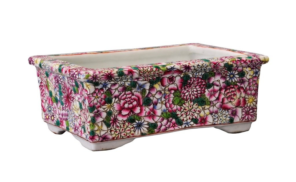 A FAMILLE-ROSE FLOWER POT: Painted to the exterior of the rectangular pot in famille-rose with various blossoms in pink and yellow and various leaves in dark green and bright green. 6 1/8 in. (15.6 cm) long, 4 1/8 in. (10.5 cm)