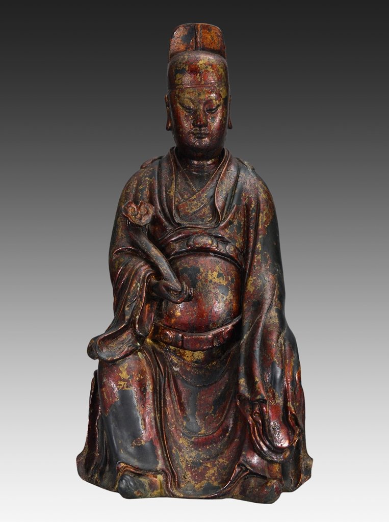 A GILT-LACQUERED BRONZE FIGURE OF OFFICER: The figure is a seated officer wearing traditional robe and holding a long scepter in one hand. The figure is wearing a long law enforcer hat. On the base of the figure is double vajra 19 1/2 in. (49.