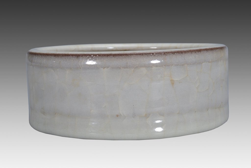 A GUAN-GLAZED WASHER: The washer is wide cylinder-shaped and the exterior is decorate with an overall plae blue color tone. 2 7/8 in. (6.2 cm) tall, 6 1/2 in. (16.5 cm) diameter. Song Dynasty
