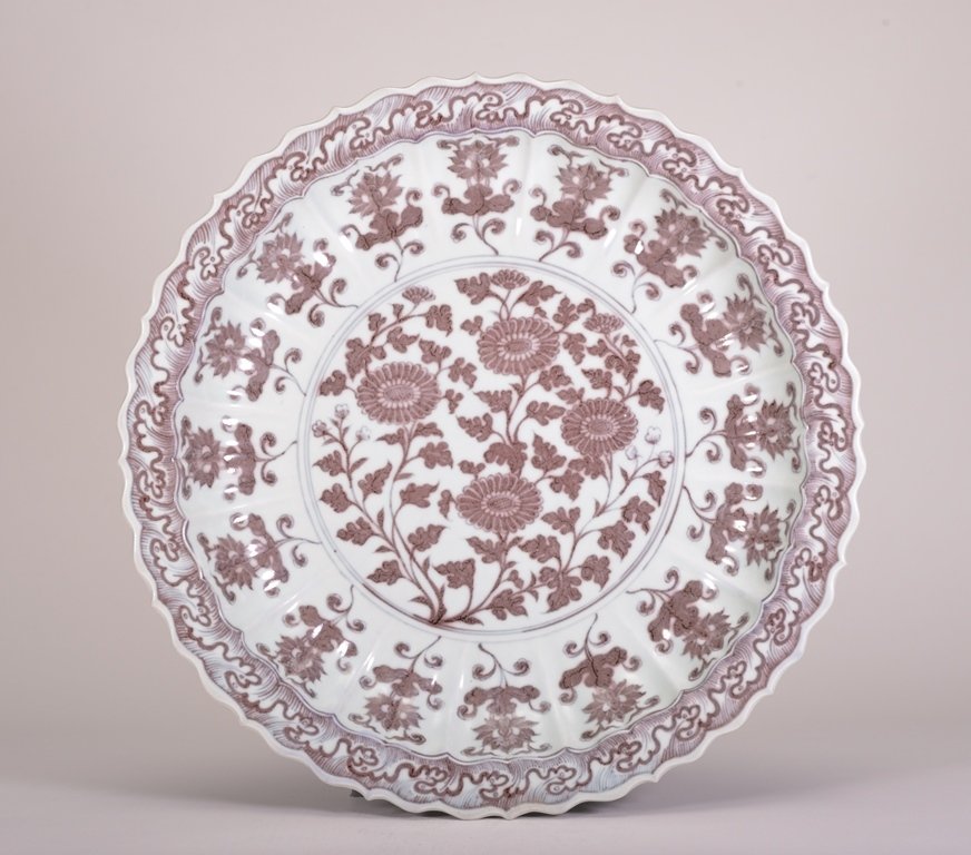 A LARGE IRON-RED DISH: The dish is concave-shaped and the exterior is decorated with numerous flower blossoms. Ming Dynasty 3 in. (7.6 cm) tall, 18 11/16 in. (47.4 cm) wide.