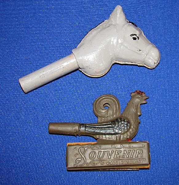 TWO FIGURAL GERMAN NOISE MAKERS: First is in the form of a tin rooster, which has a noise maker and a harmonica. Has some wear to original paint. Second is a pressed paper, hand painted donkey head. Has some very slight rubbing to th