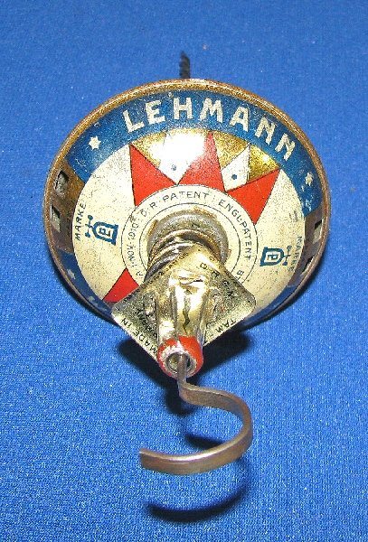 LEHMANN TAM-TAM SPINNING TOP #677: Complete with original rod and finger slide. Tin litho top patented 1910, light play wear, oxidation to plating. Size: 3" diameter 9.5" rod