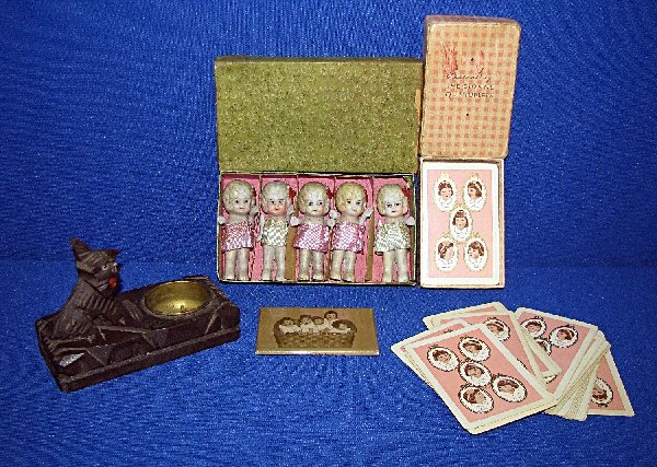 FOUR DIONNE QUINTS ITEMS: Full deck of Dionne Quints playing cards, a Dionne Quints pocket mirror which is possibly a reproduction, boxed set of Quints Japanese bisque dolls, and a carved wood figural incense burner marked fro