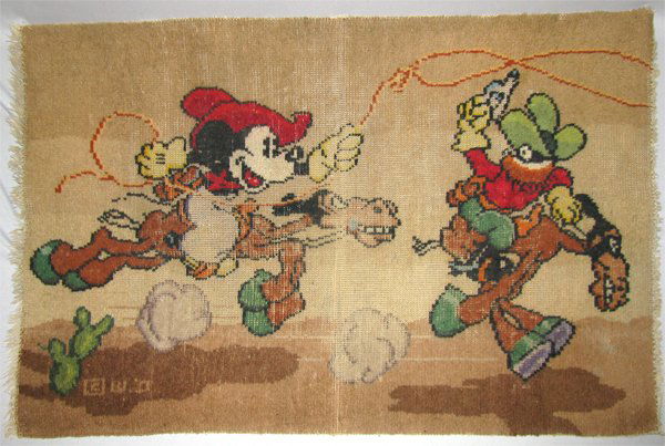 1930S MICKEY MOUSE RUG: Wool rug features a Cowboy Mickey on Tanglefoot chasing Peg-Leg Pete. Some minor wear to center along fold line, right side is missing most of the fringe. Size: 41" long x 36 3/4" tall