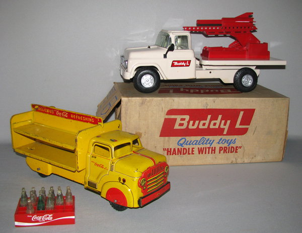 TWO PRESSED STEEL TRUCKS: Includes boxed Buddy "L" No. 5405 Mobile Missile Launcher, missing missiles (say that five time real fast). One mounting bracket for launcher partly broken. Finish crisp and bright. Original box is co
