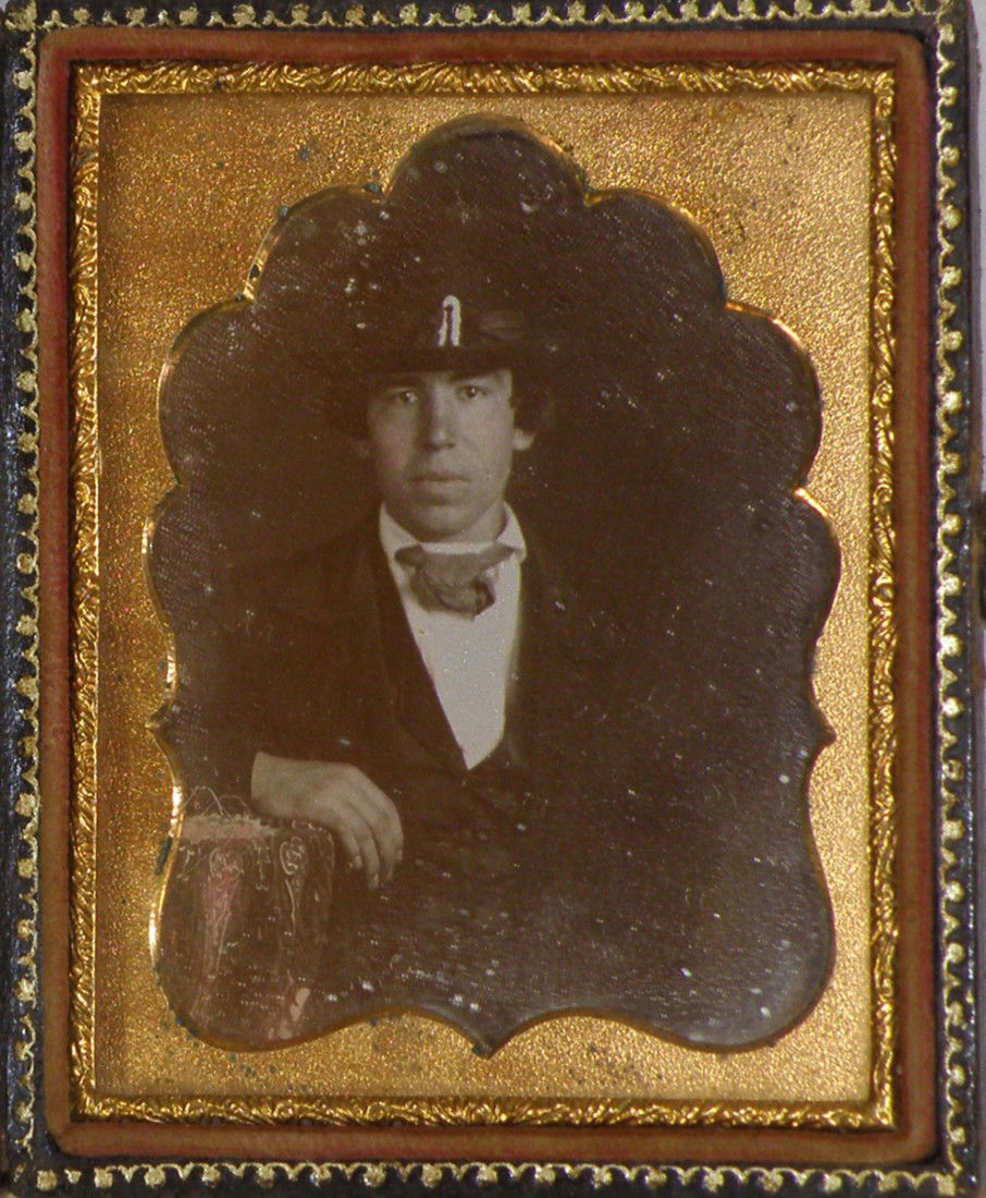 CASED 1/6 PLATE DAGUERREOTYPE OF A WELL DRESSED MA: Beautiful image of a man in a top hat and suit, with just the slightest tinting to cheeks, in embossed leather case, case has some surface wear.