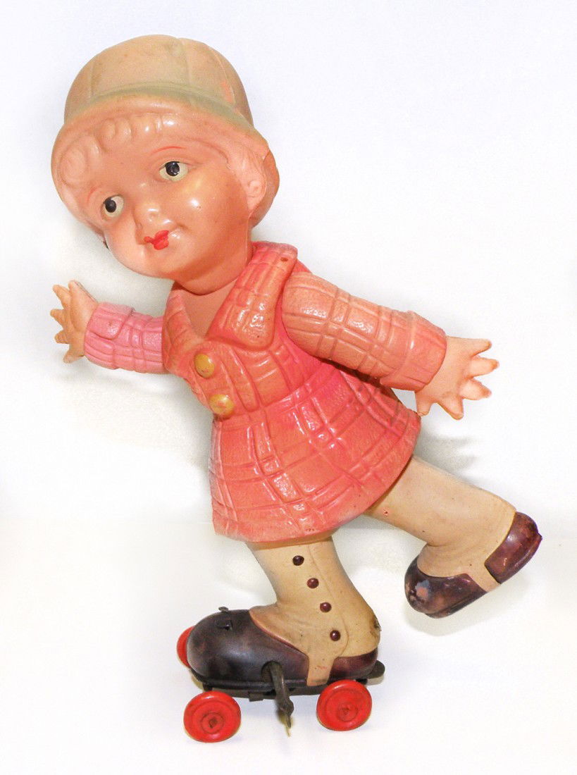 PRE WAR JAPANESE CELLULOID ROLLER SKATER: Celluloid toy with wind up skate on left foot, working mechanism sends girl in erratic pattern, one arm is discolored but original, hat has a couple of very small dings. Size: 8 inches tall