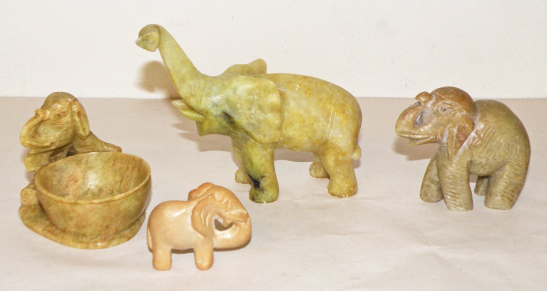 FOUR CARVED SOAPSTONE ELEPHANTS: Including small bowl with chipped rim. Size: Largest: 4 1/2"