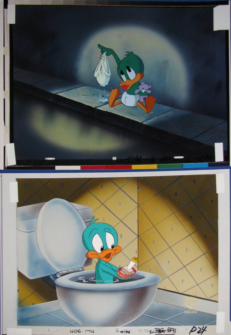 TWO ORIGINAL WARNER BROS. PLUCKY DUCK ANIMATION CE: Both cels of Plucky from Tiny Toons Adventures on photographic backgrounds. First shows Plucky taking a bath in the toilet with a little boat in his hands. Cel also has gold Warner Bros. Animation Art