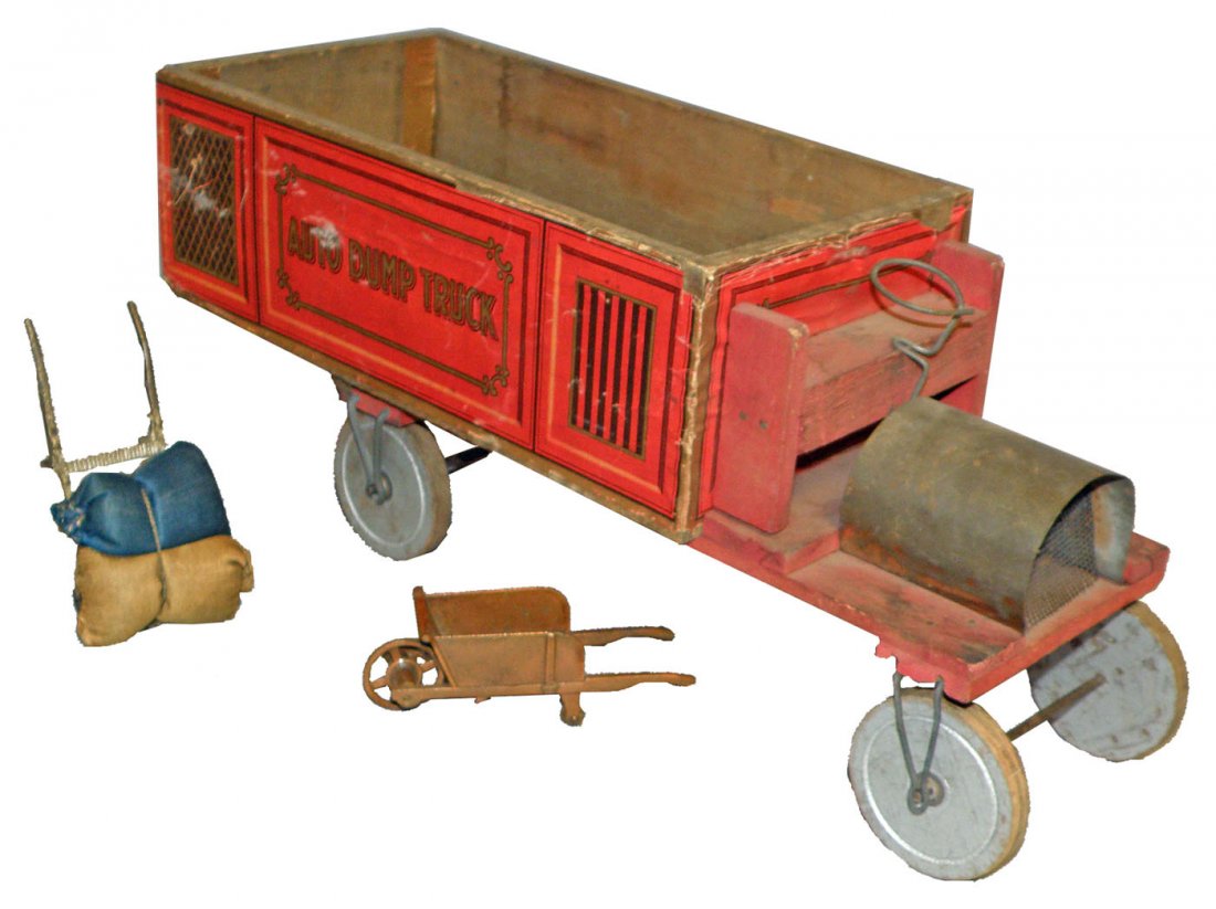 PAPER ON WOOD AUTO DUMP TRUCK: Scarce paper litho on wood auto dumptruck C-1915. Complete. Has some rippling and paper loss to bed of truck. Damage where front axels mount. Comes with period handtruck, wheelbarrow, and barrel. Size