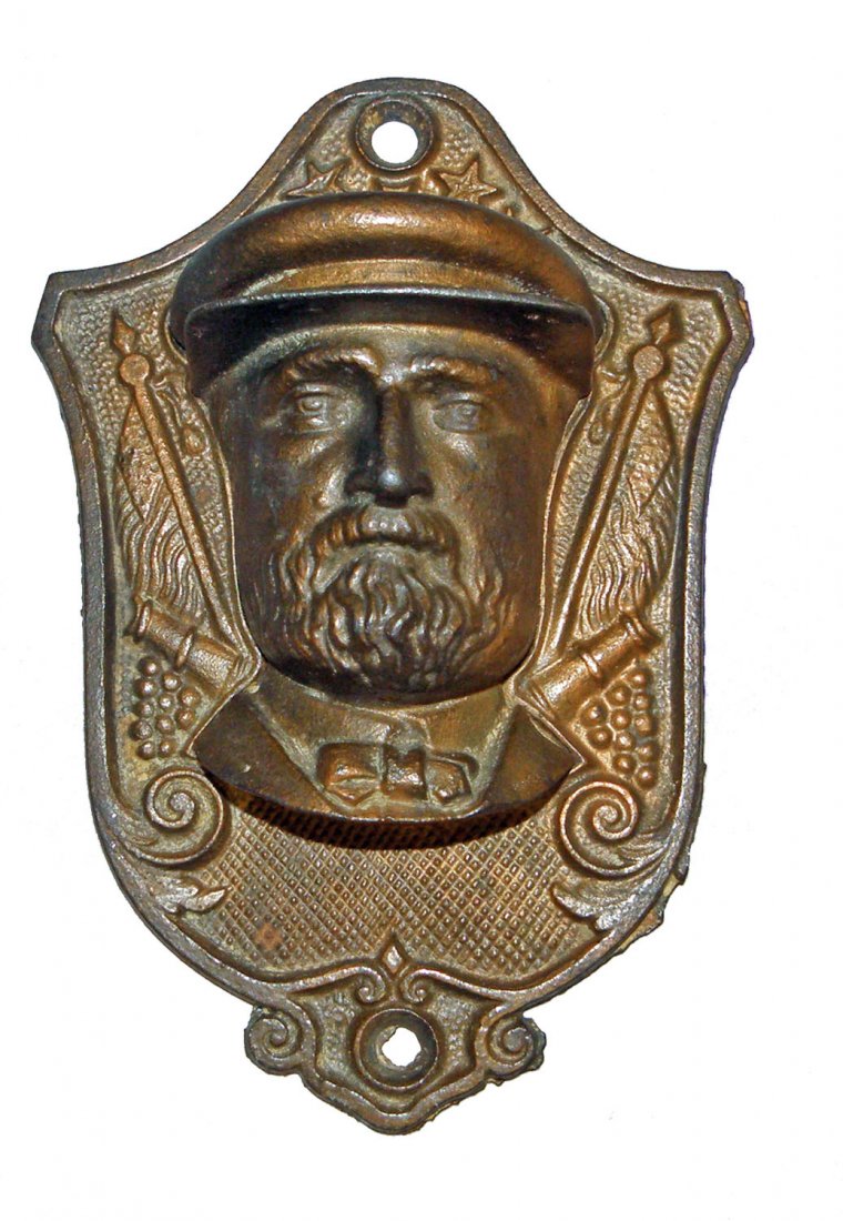 CAST IRON FIGURAL MATCH HOLDER OF U.S. GRANT: Patriotic match holder, pocket in the shape of Grant's face, base plate has flags, cannons and stars. American C-1868, some wear to copper washed finish. Size: 6" tall, 4-1/8 inches wide