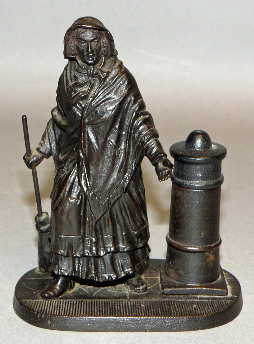 CAST IRON FIGURAL MATCH SAFE OF A LONDON STREET SW: Another book example made by E. G. Zimmermann in Germany. from "Match Holders, 100 Year of Ingenuity" by Denis B. Alsford, Schiffer Publication, 1994, figure 10, page 11. This figure is a female stree