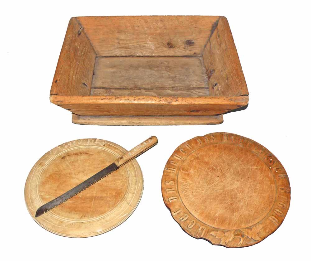PRIMITIVE DOUGH BOX, BREAD BOARDS, AND KNIFE: Dough box shows extensive age and use wear, as do the bread boards. Both bread boards have carved borders (one has edge carvings in Swedish letters). Bread knife is a Sheffield blade with a hand carve
