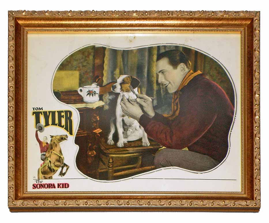 LOBBY CARD FOR THE SONORA KID: 1927 film starring Tom Tyler. Card with funny scene depicting Tom shaving his Jack Russell terrier. Tack holes to top center. Light surface wear. Size: 14" x 11"