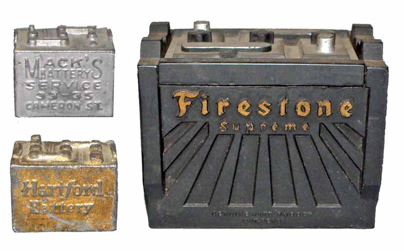 THREE PAPERWEIGHT AUTOMOBILE BATTERIES: One is hard rubber Firestone Supreme, doubles as a cigarette box. Small lead Max Battery Service, and a small lead Harford Battery. Surface wear, small chip to hinge on Firestone. Largest 3 1/2" long