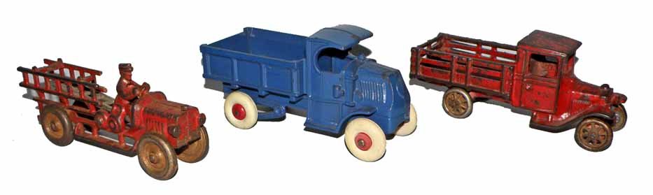 THREE CAST IRON TRUCKS: Repainted Mack Dump, Arcade Stake body Model T and a cast iron fire truck with broken ladder. Largest 7" long
