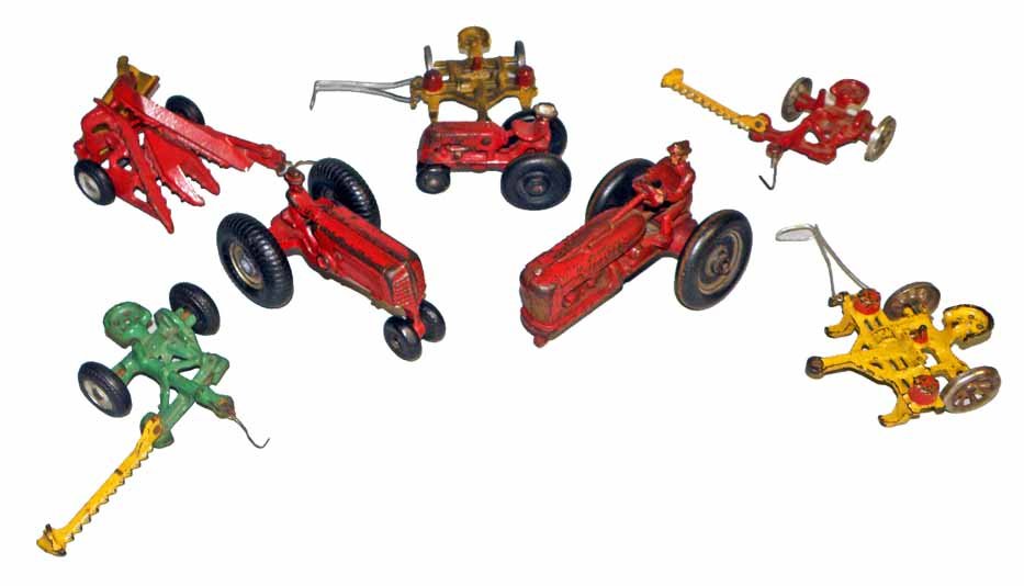 EIGHT CAST IRON TOY TRACTORS AND ACCESSORIES: Mostly by Arcade. Three tractors, one missing front wheels. Two mowers, two rakes, one repainted, and a hay cutter. Largest is 5-1/4" long