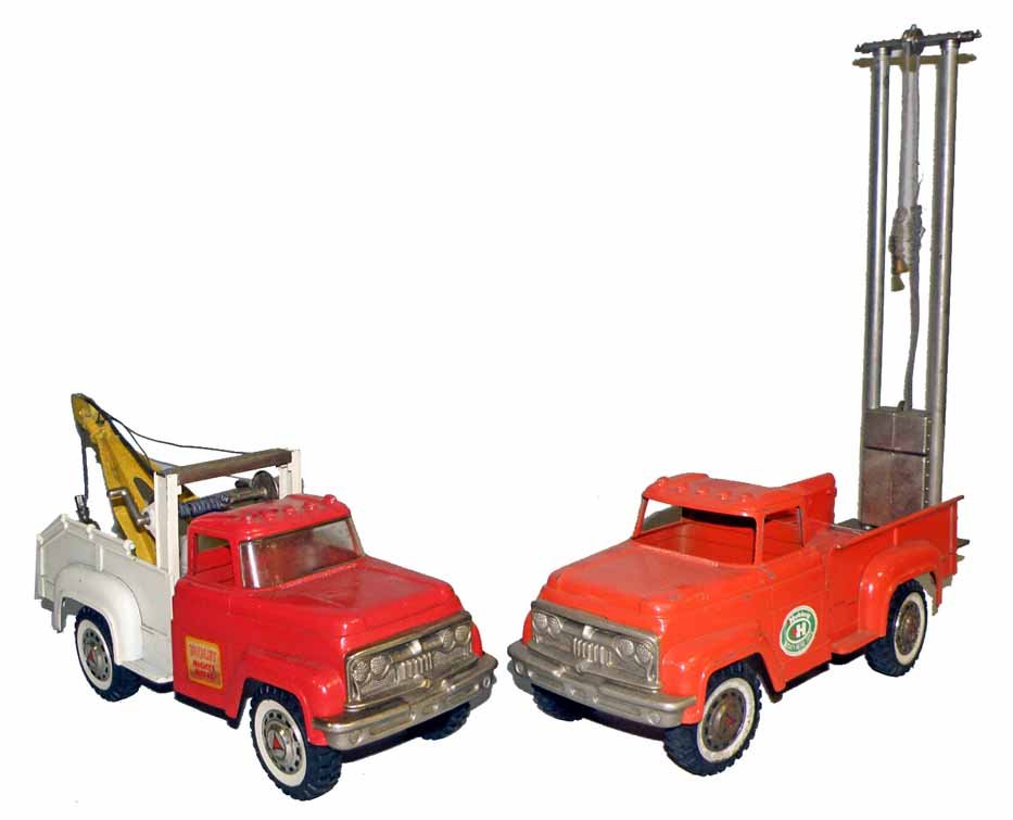 TWO HUBLEY DIE CAST TRUCKS: A tow truck, missing one hub cap. And a pile driver that is complete. Scattered paint chipping to both. 12-1/2" long