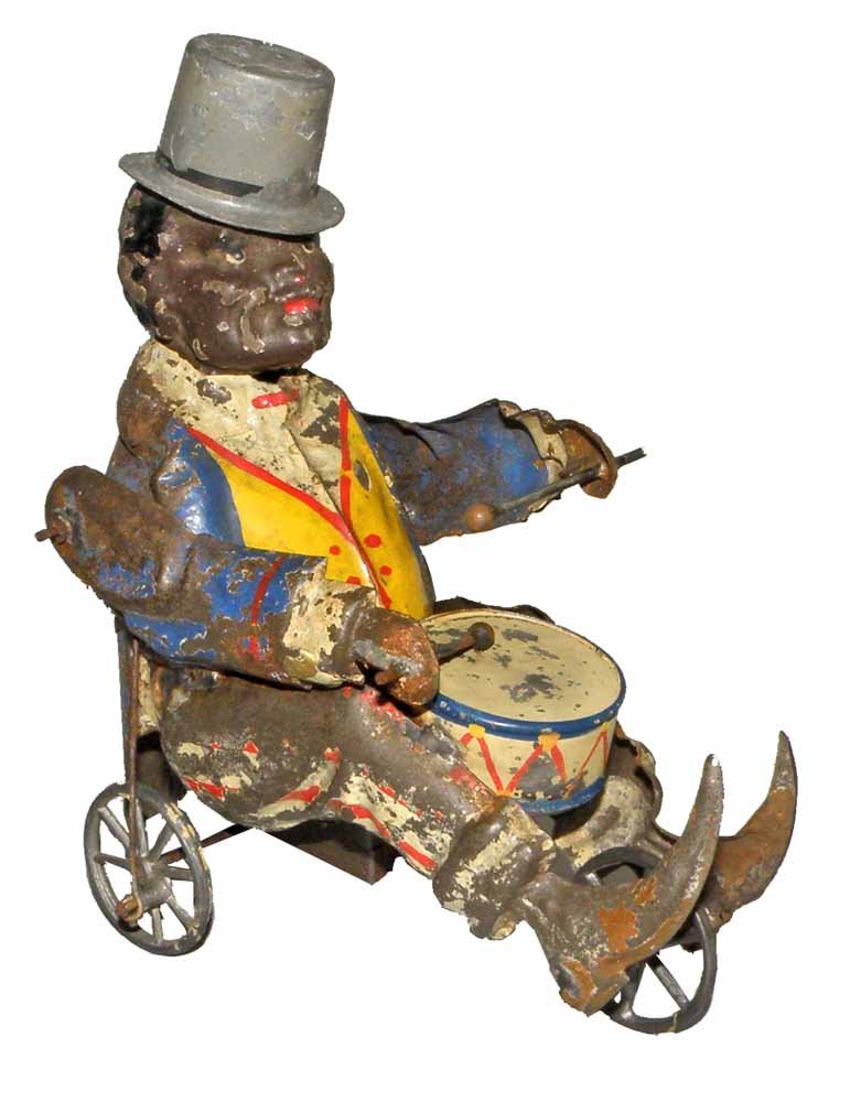 HAND PAINTED GERMAN TIN BLACK DRUMMER: Great design of well dressed black man playing drum. Significant paint loss except to drum and vest. 6" long, 7" tall