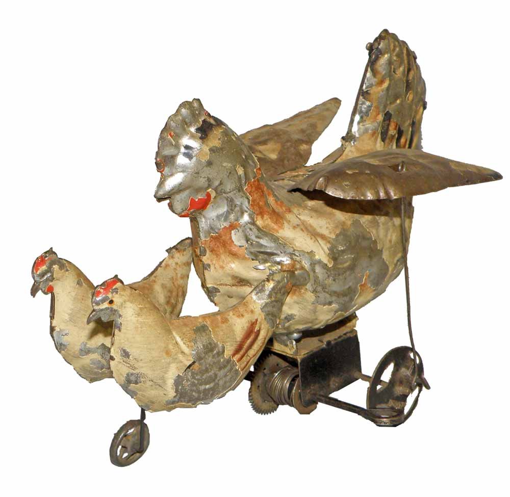 HAND PAINTED HEN AND CHICKS: Wind-up mother hen with flapping wings. Wheels marked Germany. Scattered paint loss. 7-1/4", 5-3/4" tall