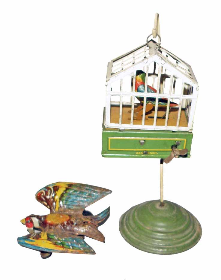 TWO WIND UP BIRD TOYS: Small German bird house on stand. Works fine. Light scratching and soiling. German swallow has wear to finish.Largest 8" Tall