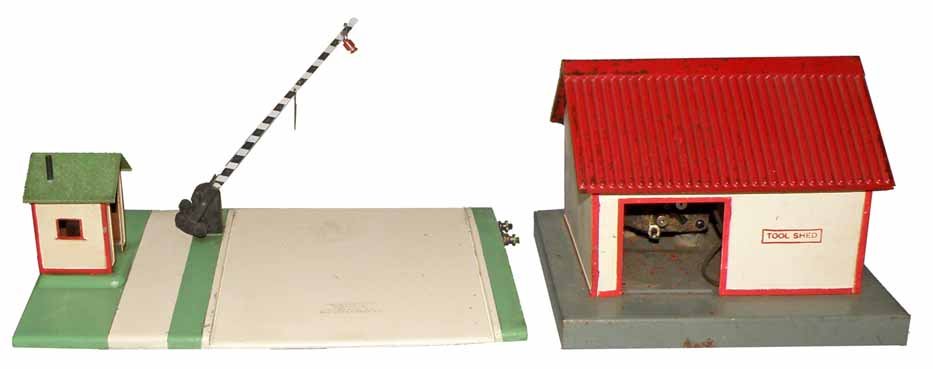 TWO AMERICAN FLYER ACCESSORIES: #585 Tool Shed is missing sliding door and a #592 Crossing Gate that is complete. Both show some wear.Largest 10 1/2" Long