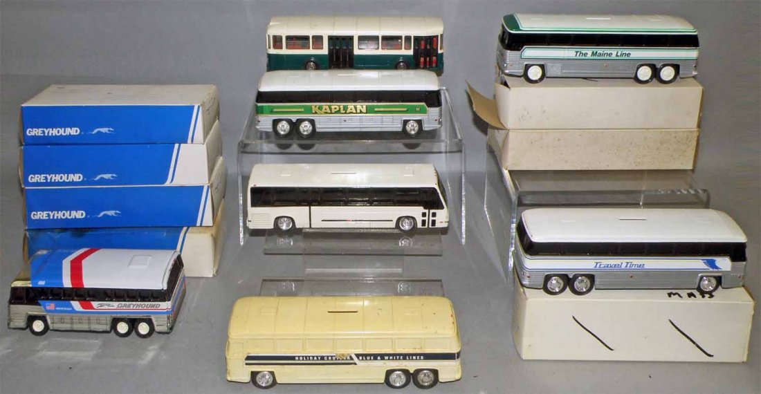 LOT OF TWELVE PLASTIC AND METAL BUSES: American and European. Includes four boxed Greyhound Ameri-Cruiser banks, two boxed Maine line banks, boxed Travel time bank, Caplan bank, Holiday cruiser bank. Also has auto bus by Norve. Unmarked bu