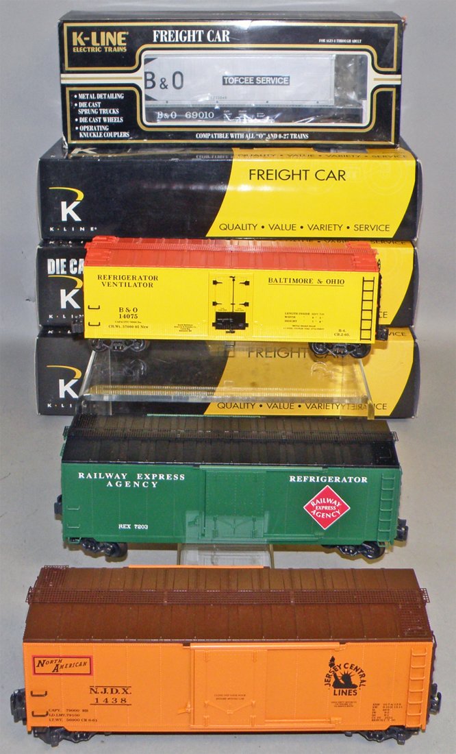 FOUR BOXED K-LINE FREIGHT CARS: Unused. #K-69010 B&O Flat car with container, #K761-1232 Jersey Central Box car, #K752-1091 B&O Reefer, #K761-1912 REA reefer. Size: 12" long