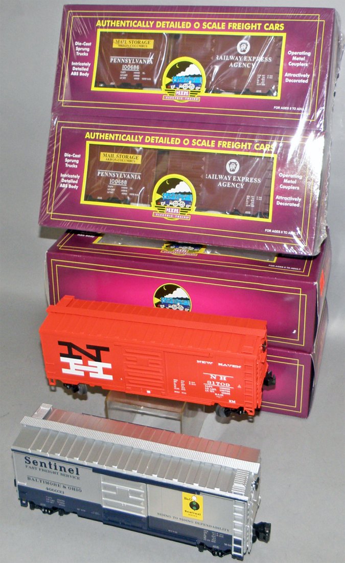 FOUR BOXED MTH FREIGHT CARS: Unused. #20-93048 NH box car, #20-93143 B&O Sentinel Box car, two # 20-93122 PRR Box cars. Size: 14" long