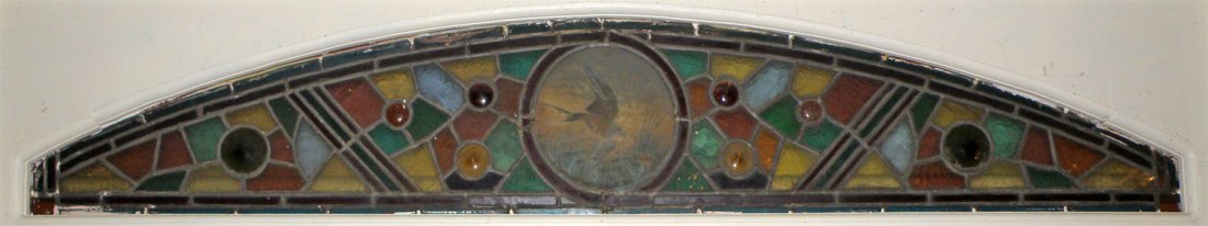 UNUSUAL STAINED GLASS TRANSOM WINDOW: Arch form. Center panel hand painted with swallow. Couple minor cracks. 66" wide x 11 1/2" tall There are 100's of non-cataloged items. Antique to contemporary lighting, stained glass, farm and shop a