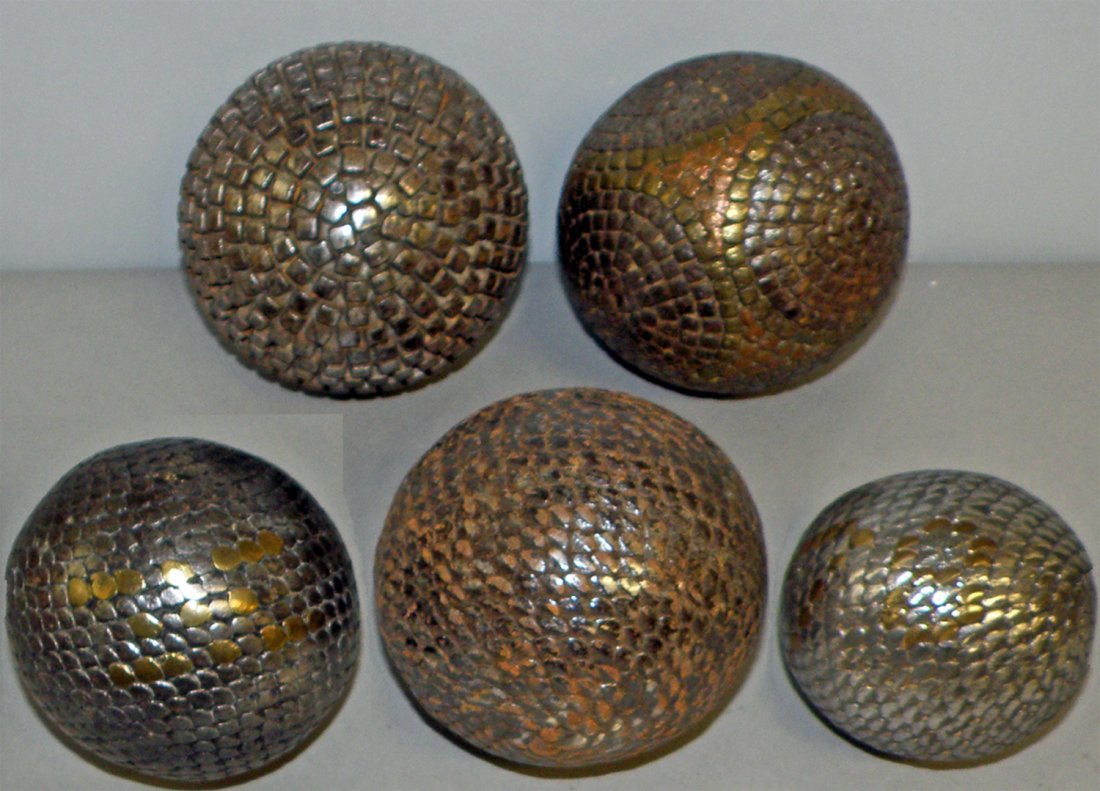 FIVE ANTIQUE BOULES: Wood balls with iron, copper and brass nails. Nails are hammered in a very decorative pattern. Probably 19th century. largest 4" diameter
